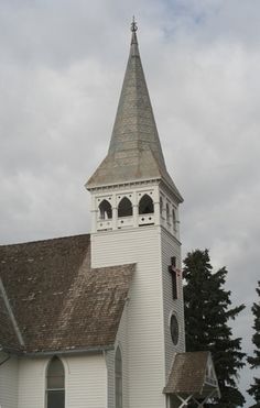 an old white church with a steeple and clock tower