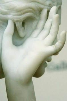 there is a white statue with hands on it's face