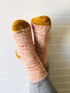 someone is holding their feet up wearing socks made out of knitted wool and yarn