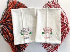 two white towels with red and blue tassels next to each other