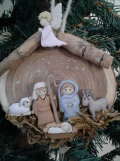 a christmas ornament with nativity scene on it's tree branch in the shape of a house