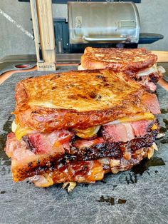 two toasted sandwiches sitting on top of a cutting board next to an open oven