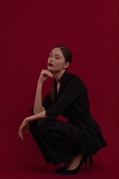 a woman kneeling down with her hand on her chin