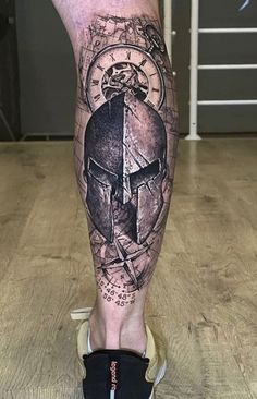 a man's leg with a helmet and compass tattoo on it