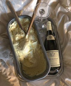 two bottles of wine and ice cream in a metal container