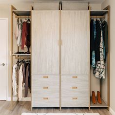 an open closet with clothes and shoes hanging on the doors, in front of a white rug