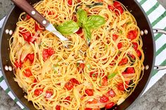 a skillet filled with pasta and tomatoes