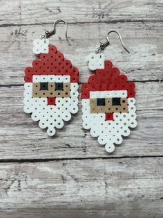 the santa claus earrings are made out of perler beads, and have white dots on them