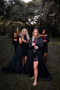 four women dressed in black posing for the camera