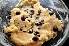 an uncooked cookie in a glass bowl with chocolate chips on the top and bottom