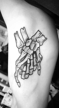 a black and white photo of a skeleton's hand with bones on it tattoo