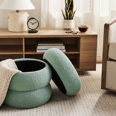 two bean bags sitting on the floor in front of a table with a clock and lamp