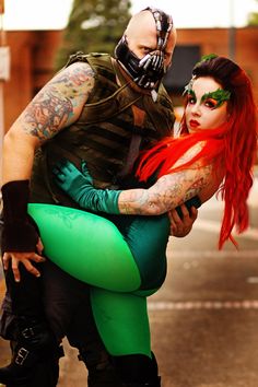 a man and woman dressed up in costumes hugging each other on the side of the road