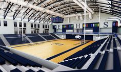 an indoor basketball court with blue and white seats