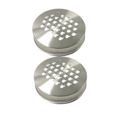 two metal grinders sitting side by side on a white surface with holes in the middle