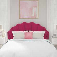 a bed with pink headboard and pillows in a white walled bedroom, along with two nightstands