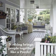 the porch is decorated with white wicker furniture and potted plants on either side