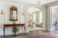 an ornate entry way with white walls and wood floors