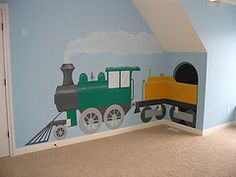 a child's room with a train mural on the wall and carpeted floor