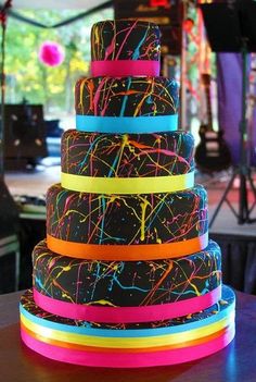 a multi - tiered cake with colorful ribbons on it