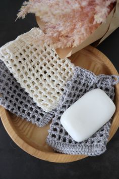 a wooden plate topped with soap and crocheted dishcloths