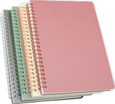 three spiral bound notebooks stacked on top of each other, one pink and the other green