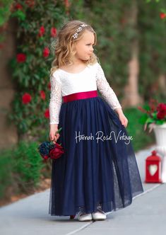 Our Navy Flower Girl Dress is a splendid addition to your blue wedding themes for Spring and Summer. Radiating beauty and sophistication, this dress seamlessly combines a lovely white lace bodice with a captivating flowing tulle skirt. Handcrafted with precision, it offers a perfect fit and unparalleled comfort, allowing your child to revel in sheer elegance on any special occasion. *Please choose sash style and include your sash color in notes at check out Additional Sashes are available here: Bridal Sashes Purchase Chiffon Flower Sash here , Purchase Rolled Flower Sash here Color: Bodice soft white; skirt Navy (shown with Plain Sash in Burgundy) Hand wash cold, line or dry flat Wedding Themes For Spring, Navy Flower Girl Dress, Flower Girl Dress With Sleeves, Flower Girl Hair Bows, Bohemian Flower Girl Dress, Navy Flower Girl, Flower Girl Dresses Navy, Vintage Flower Girls, Flower Girl Dresses Vintage