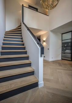 there is a light that is on above the stairs in this house with wood flooring