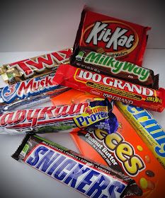 several different types of candy on a white table top, including milk and chocolate bars