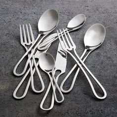 a bunch of forks and spoons sitting on top of a gray floor next to each other