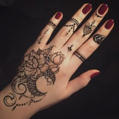 a woman's hand with henna tattoos on it