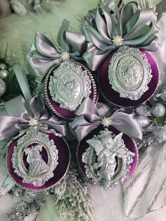 purple and silver ornaments are arranged in a bouquet