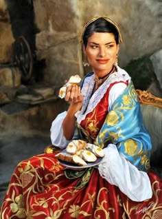 a woman sitting on a chair holding a plate of food in one hand and looking at the camera