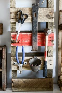 an old wooden pallet with tools hanging on it