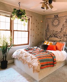 a bedroom with a large bed and a ceiling fan in the corner next to a window