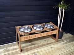 a wooden stand with three metal bowls on it