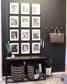 a black and white entryway with pictures on the wall, two wicker baskets underneath