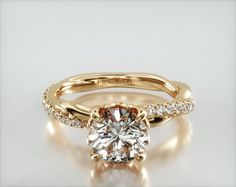 a yellow gold engagement ring with a round cut diamond in the center and side stones on each band