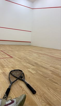 a tennis racquet laying on the floor in an empty room with red lines