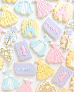 decorated cookies with princess dresses and tiaras are displayed on a white surface, as well as the words happy 1st birthday