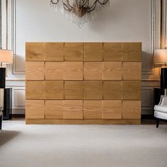 a large wooden wall in a room with lamps on either side and two chairs to the side