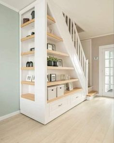 an empty room with some bookshelves and shelves on the wall next to stairs