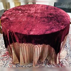 a round table covered with a red velvet cloth