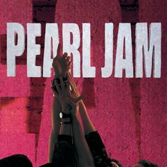 two people holding their hands up in front of a pink background with the words pearl jam on it