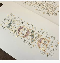 two greeting cards with the word love written in gold and silver foil on white paper