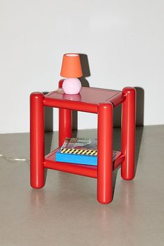 a small red table with a lamp on top