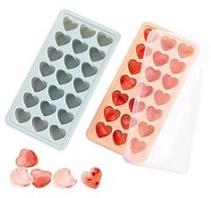 two heart shaped ice trays next to each other on a white surface with hearts in them