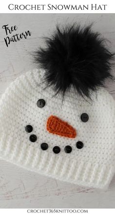 a crochet snowman hat with black fur pom - pom on top