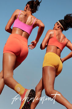 two women in sports bras and shorts are running with their hands on their hips