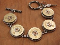 Five 12 gauge shotgun casings are nestled in the perfect rope edge bezels for a look that shows the quality and craftsmanship that we strive for in our work. Bezels allow for a finished look both front and back and give the bracelet substance and style too! We never drill casings or leave the backs of any of the casings exposed and unsightly like the other guys! Joined with stainless steel jump rings for strength and durability. Pretty rope toggle to carry out the theme. Finished with our signat Shotgun Shell Jewelry, Bullet Casing Crafts, Bullet Casing Jewelry, 12 Gauge Shotgun, Bullet Crafts, Bullet Casing, Bullet Jewelry, Shotgun Shell, The Other Guys